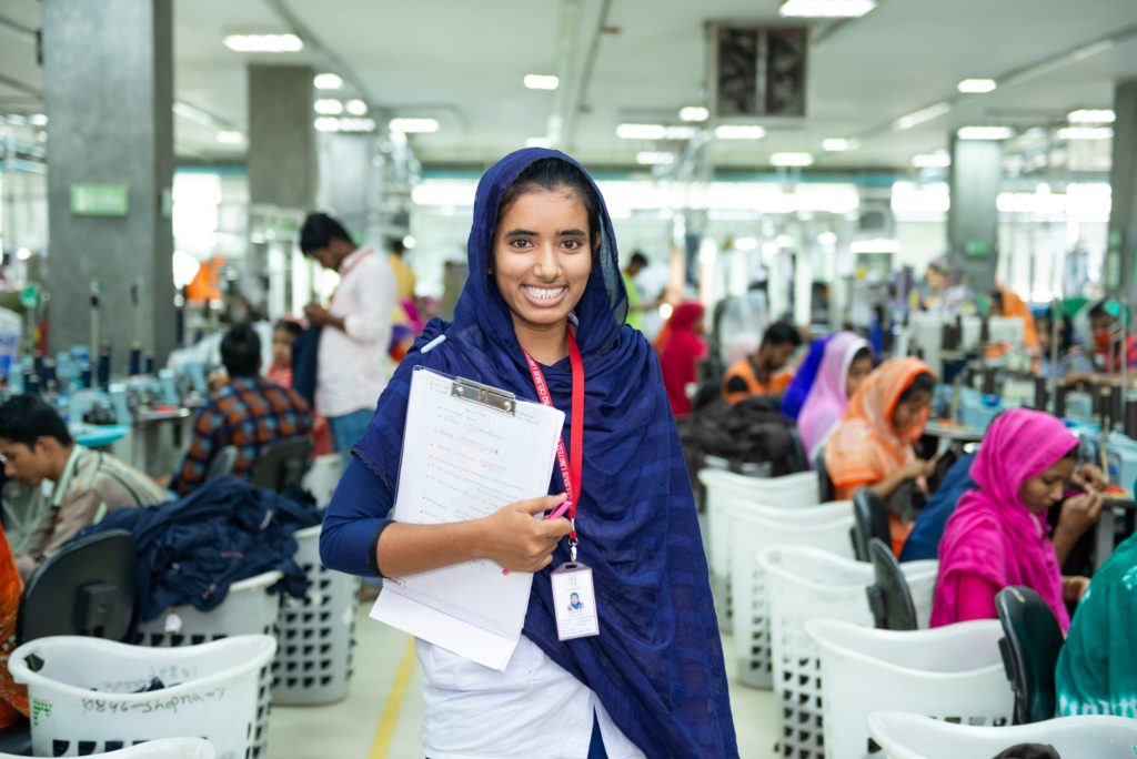 photo of woman holding clipboard in factory