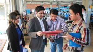 photo of four people looking at a clipboard