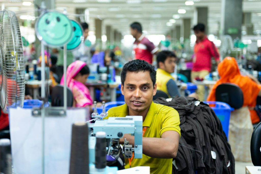 photo of man at sewing machine in factory