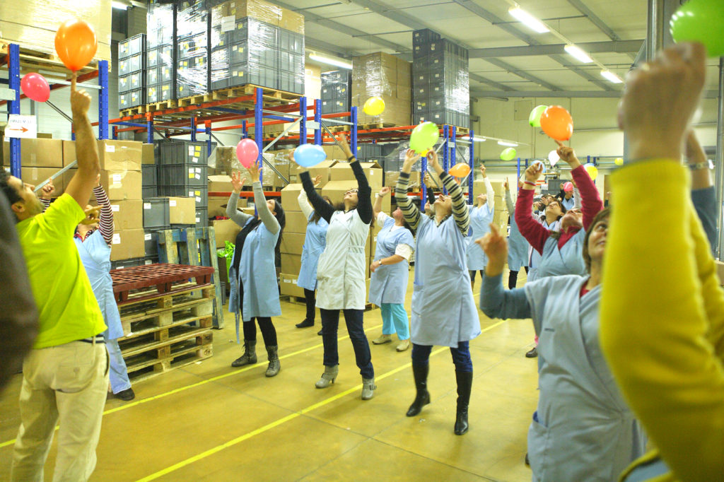 workers holding balloons in a factory