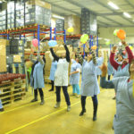 workers holding balloons in a factory