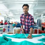 photo of man folding fabric in garment factory