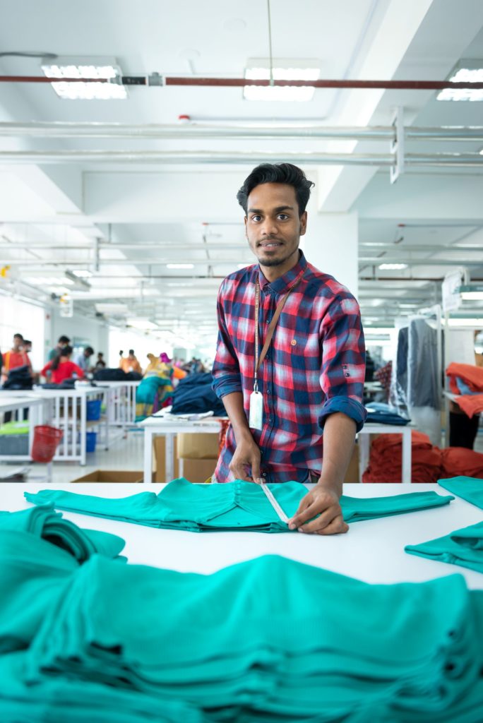 photo of man folding fabric in garment factory