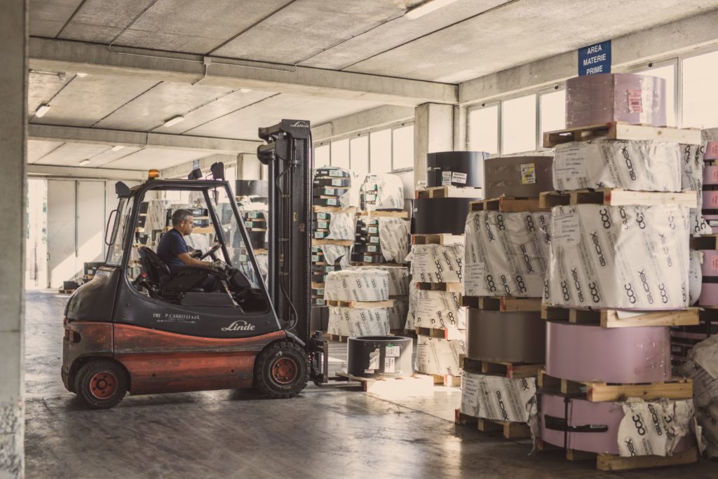 photo of man driving forklift in warehouse