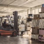 photo of man driving forklift in warehouse