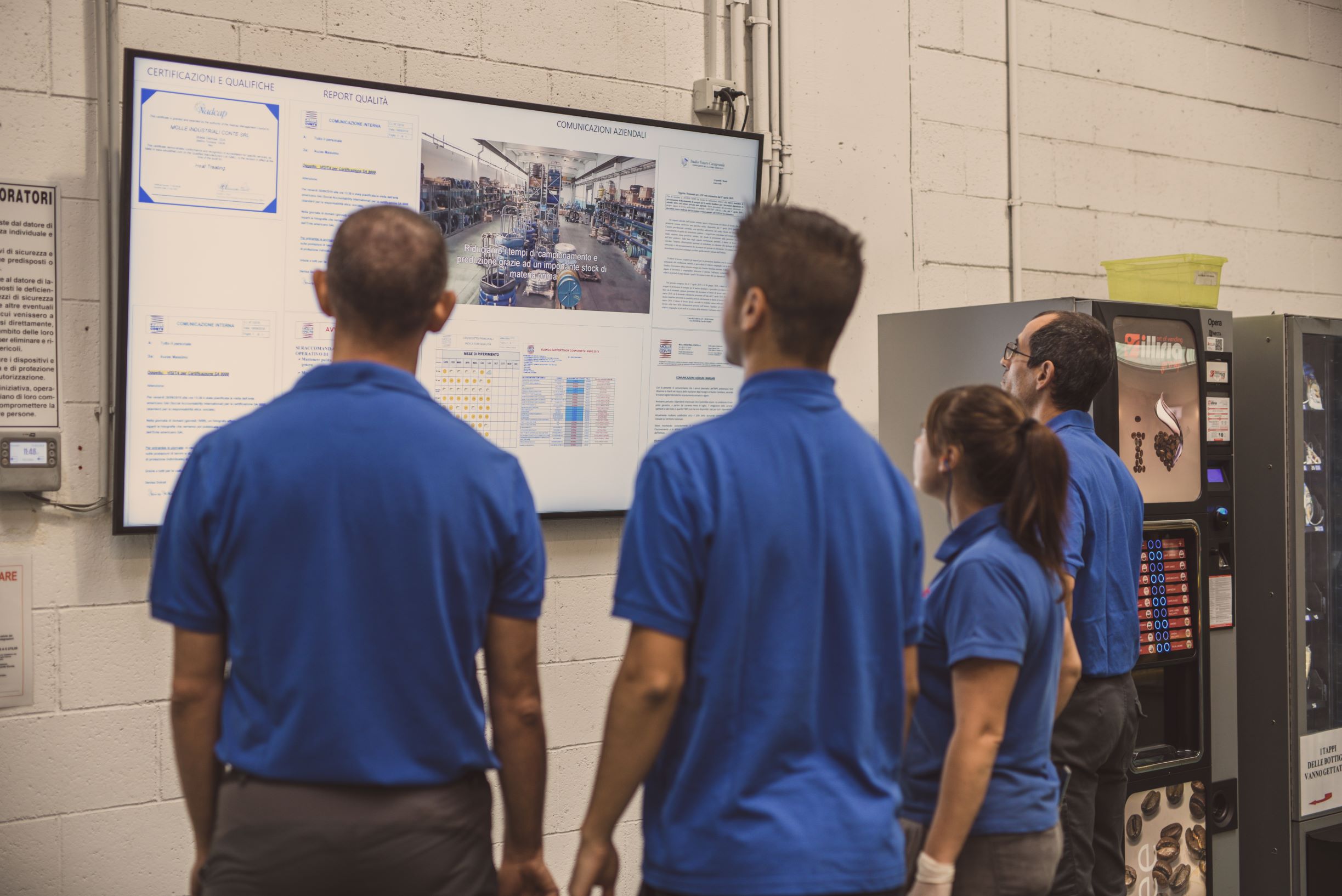 photo of people looking at a screen in a factory