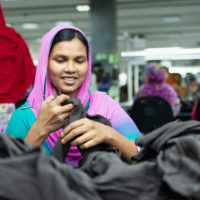 Photo of woman folding fabric in a factory