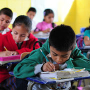 Children writing in schoolbooks, photo by Maria Fleischmann, World Bank