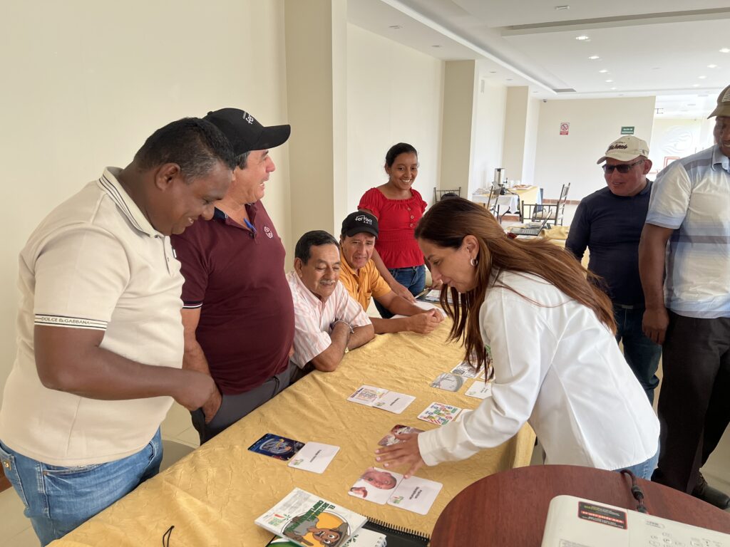 Yolanda stands at a table with six people looking at training materials