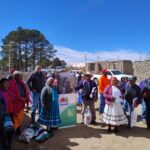 Group of people stand outside around a banner that says "Sustentar"