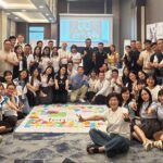 A large group of people smiles around a poster that says "TenSquared"